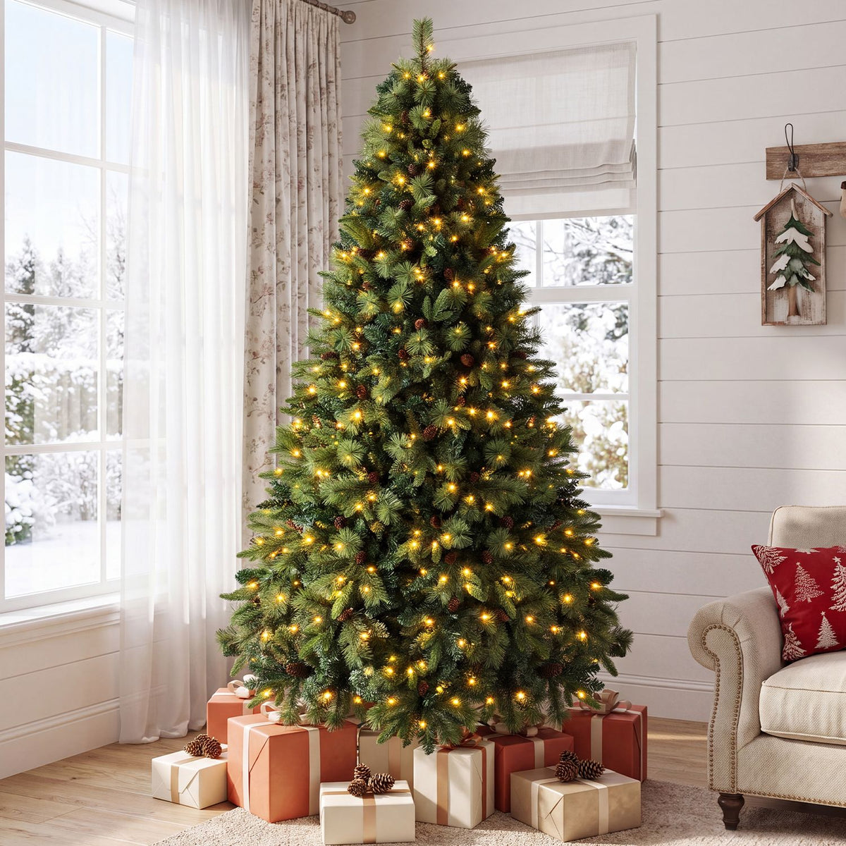 A warmly lit fir tree stands beside bright windows, with wrapped gifts arranged around its base.