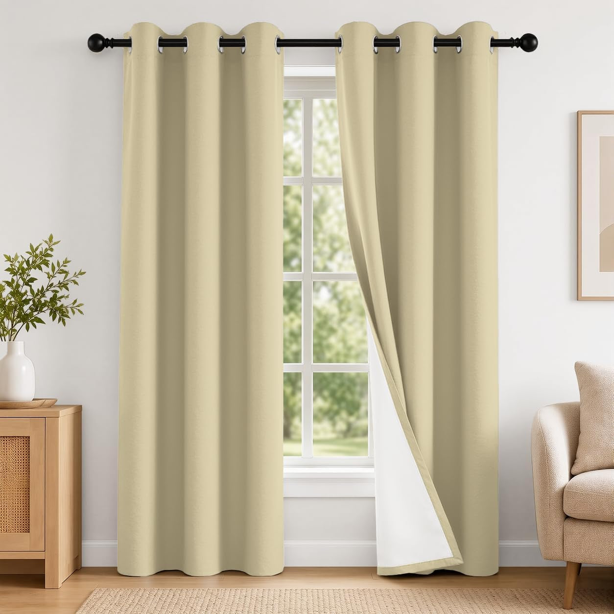Pair of beige grommet curtains hanging over a window, one panel slightly pulled to show white backing.