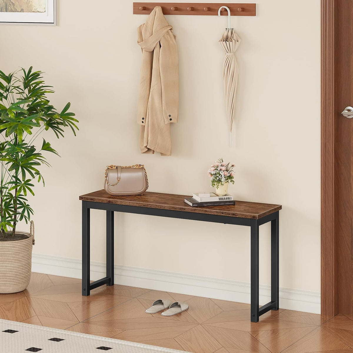 Rustic bench against an entryway wall with a purse, books and small vase on top, slippers on the floor.
