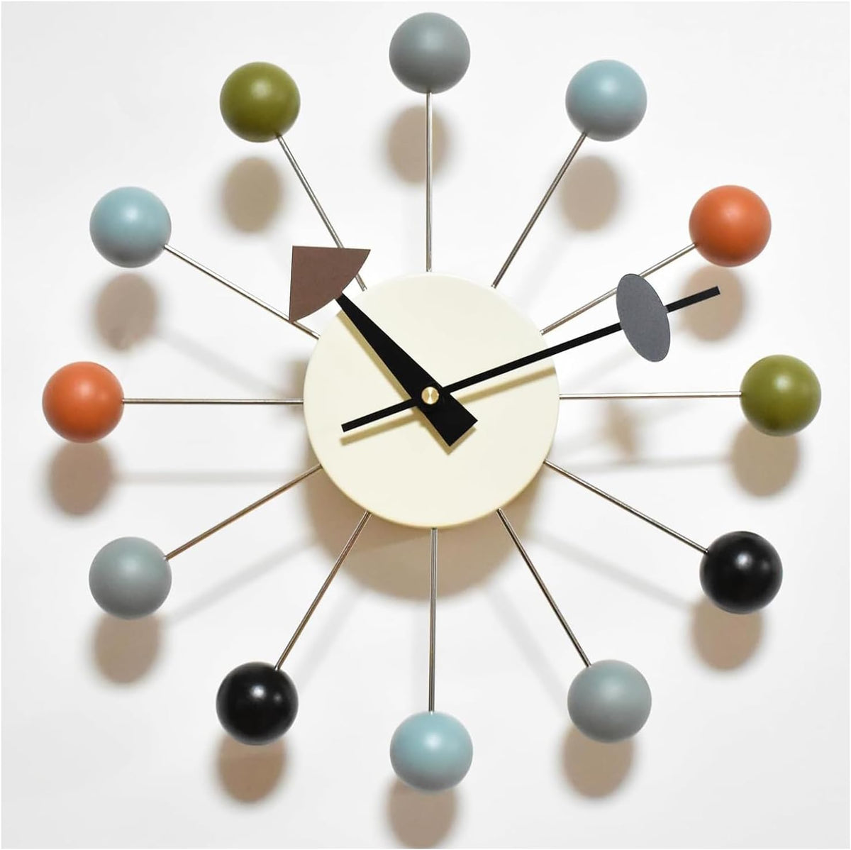 Close crop of a different clock face with cream center and multicolor spherical ball ends on metal rods.
