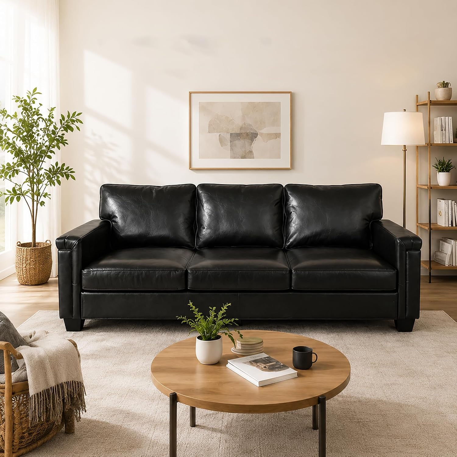 Front-facing view of a black three-cushion leather sofa in a bright living room.