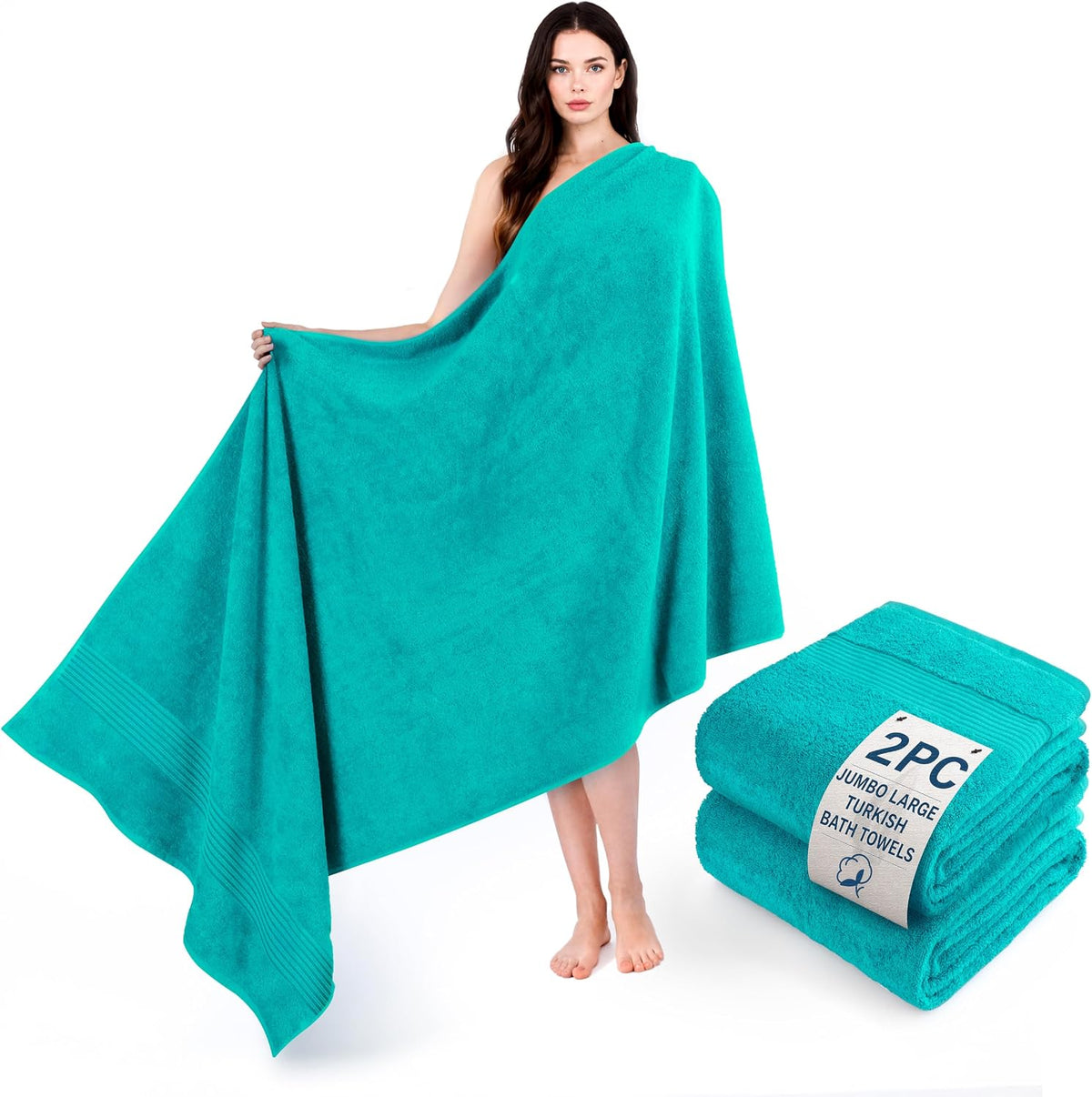 Woman wrapped in a large teal bath towel holding out one corner; stacked matching towels beside her.