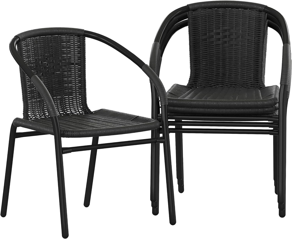 Two black rattan dining chairs, one nested on top of the other to show stacking feature.