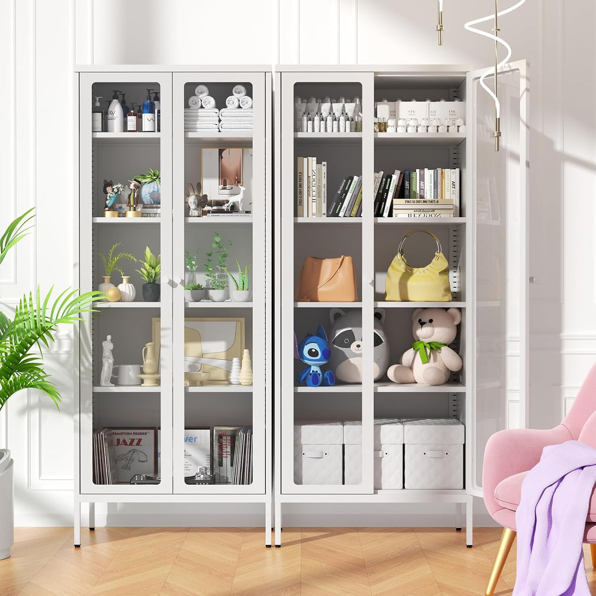Two white display cabinets side-by-side filled with books, plants, toys and storage boxes, pink armchair at right.