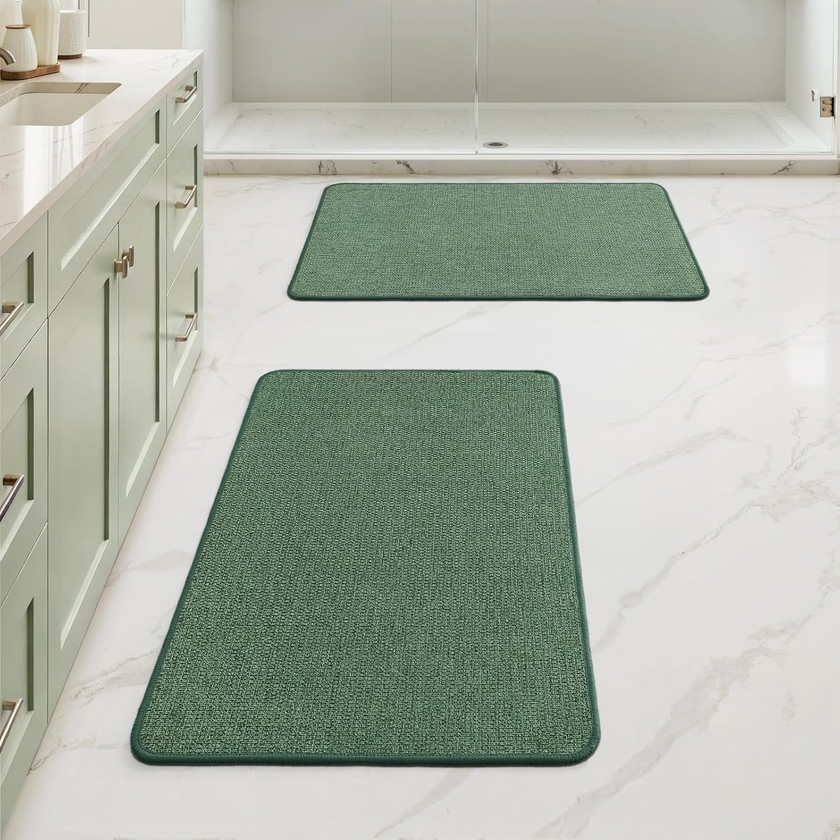 Low perspective of two deep green rectangular mats running down the floor toward a shower area.