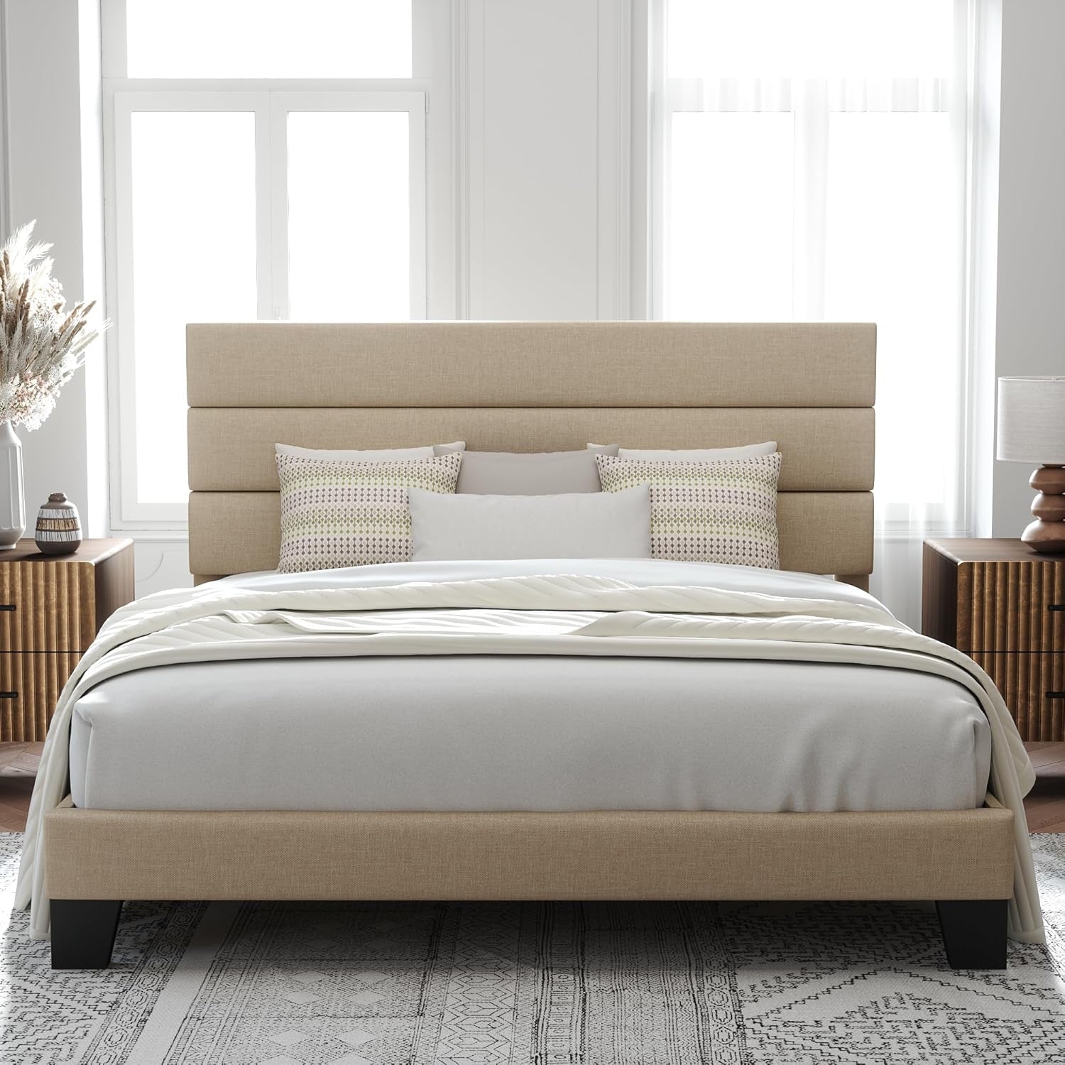 Front view of a tan fabric-upholstered bed with a three-panel headboard and black legs.