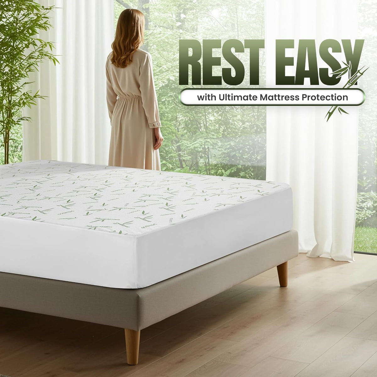 Corner view of a made bed with white bamboo-print mattress protector and a woman standing by a window looking outside.