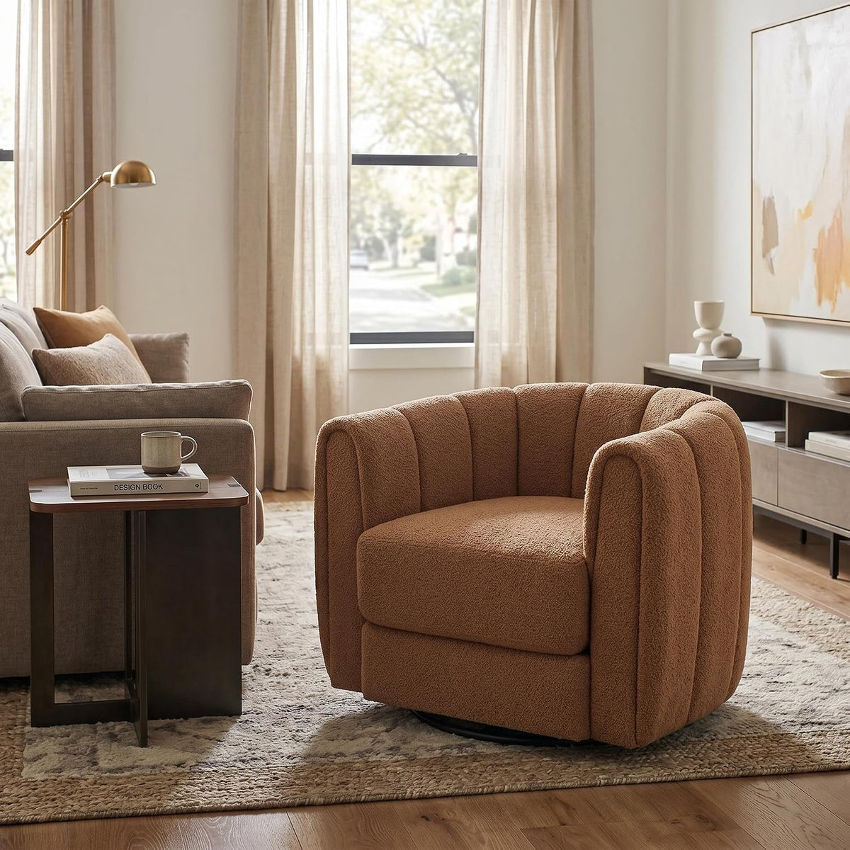 Single terracotta-brown swivel barrel chair next to a sofa and small side table in a bright living room.