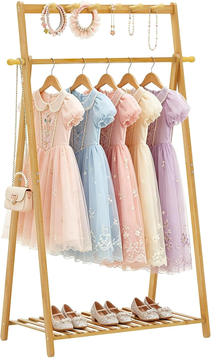 Bamboo A-frame rack displaying several pastel princess dresses hanging and pairs of shoes on the bottom slatted shelf.