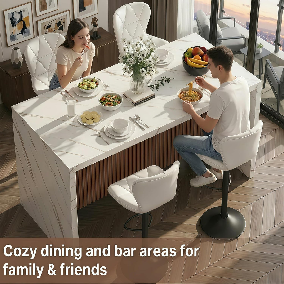 Two people sitting at a marble-look island eating, white quilted chairs and vase of flowers on top