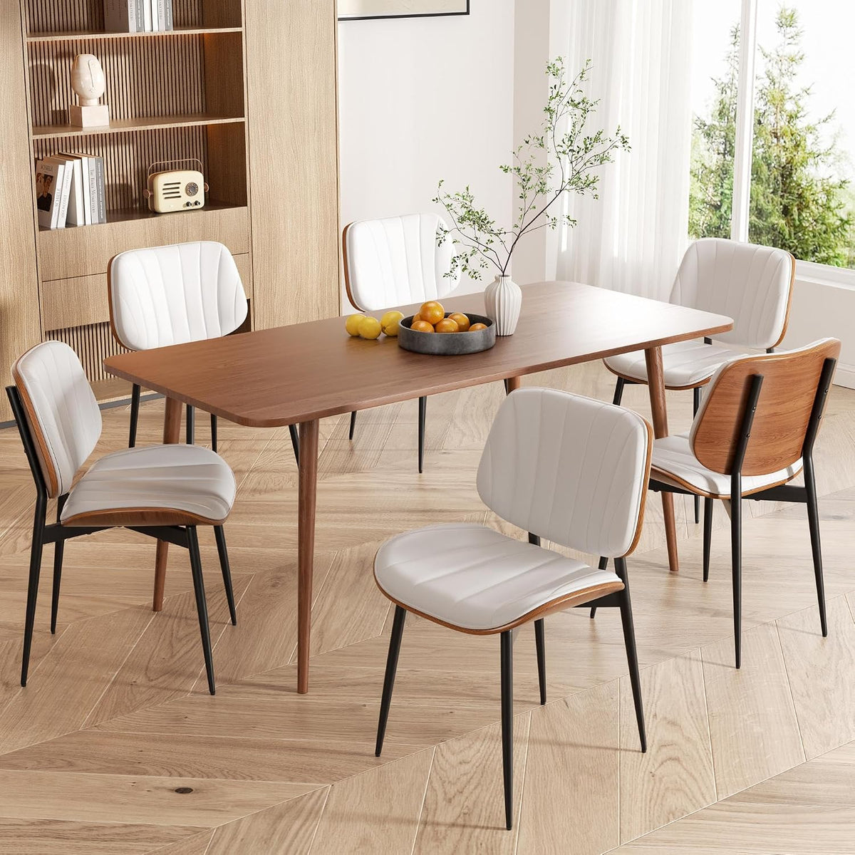 Rectangular dining table with six white faux-leather chairs and walnut bentwood backs in a bright room.