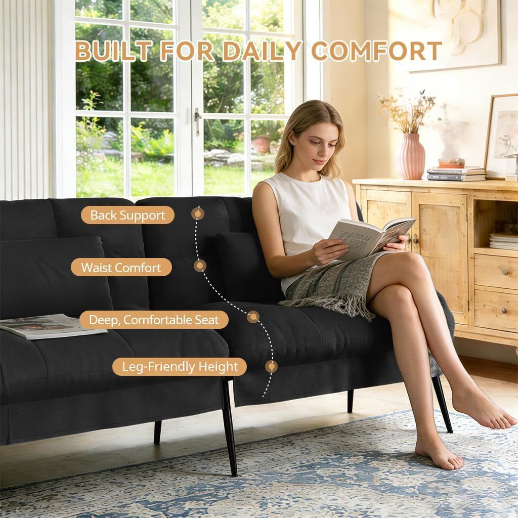 Woman seated on black futon demonstrating deep seat and lumbar support in a living room setting
