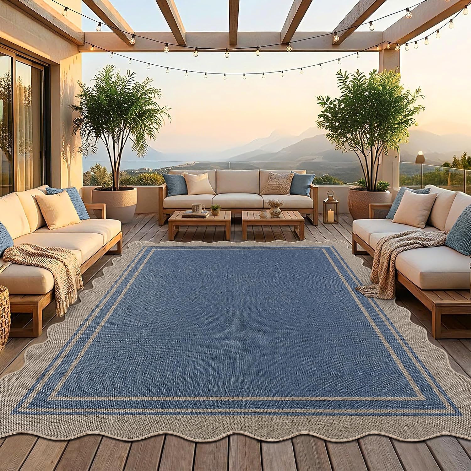 Large scalloped blue area rug on a wooden deck between outdoor sofas under a pergola