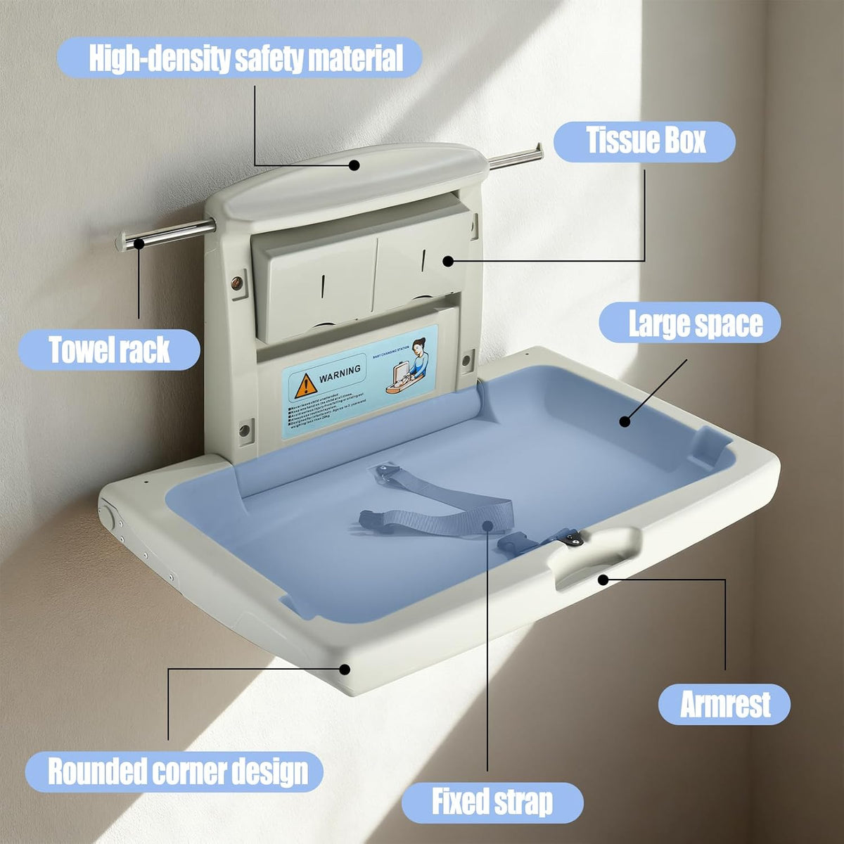 Wall-mounted fold-down baby changing station opened on a tiled wall with safety strap and towel rack