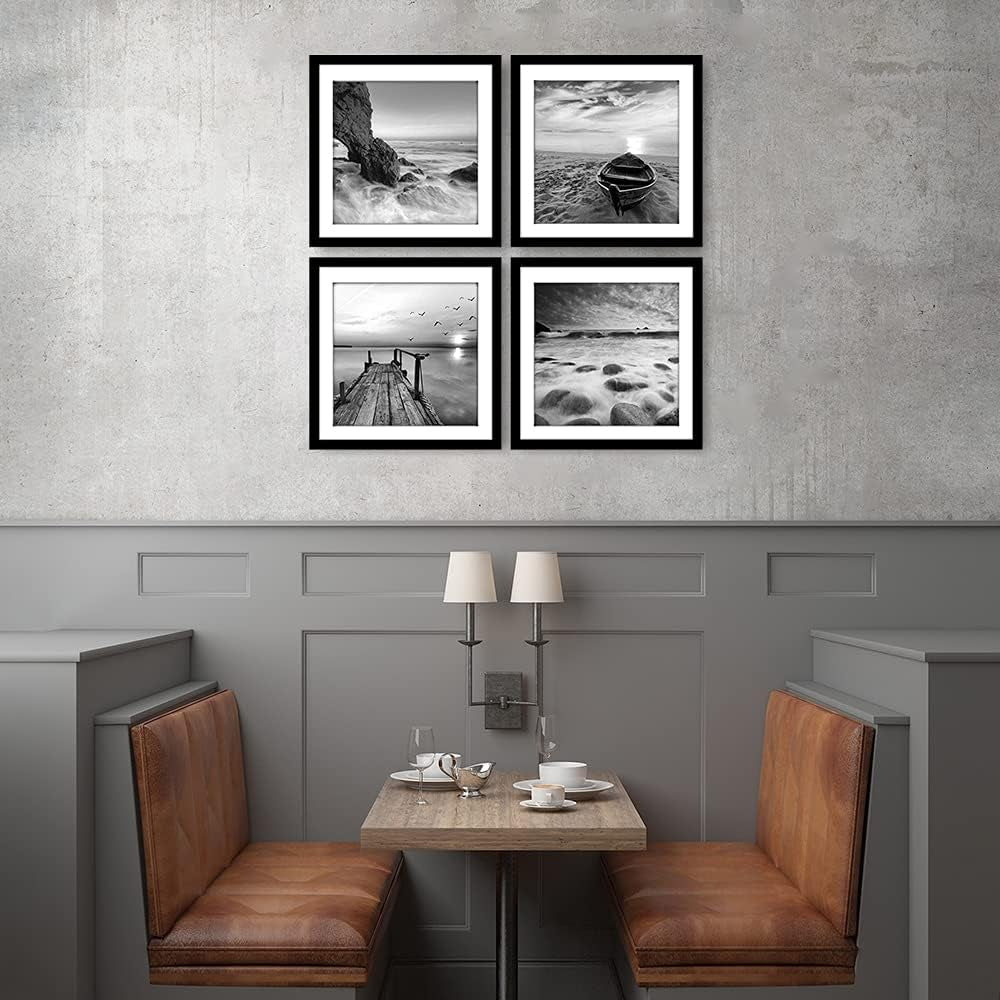 Set of four black-and-white seascape frames hung 2x2 above a small dining booth with leather seating and concrete-style wall