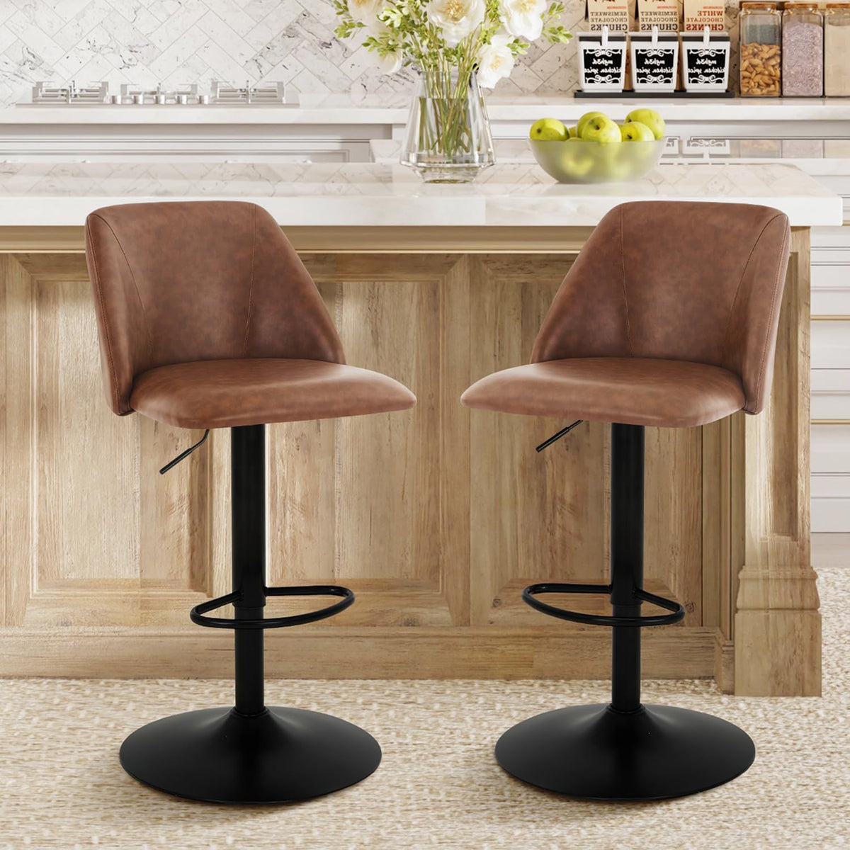 Two cognac-brown swivel bar stools with black pedestal bases at a wood-paneled island, apples and flowers on the counter