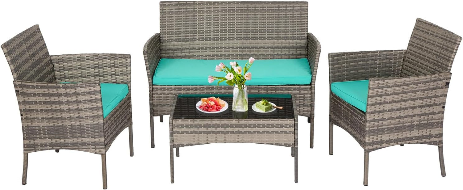 Three-seat rattan loveseat with teal seat cushion and two matching armchairs arranged around a glass-top coffee table with