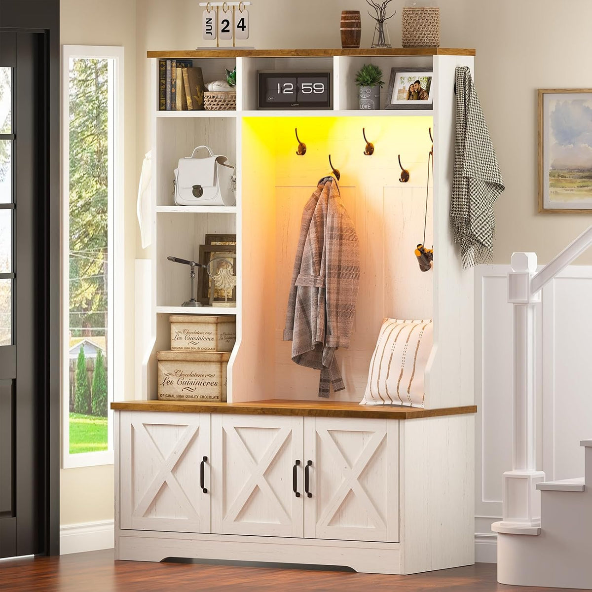 Angled view of the white hall tree in a foyer, showing open side cubbies, bench and warm LED glow inside the hook area