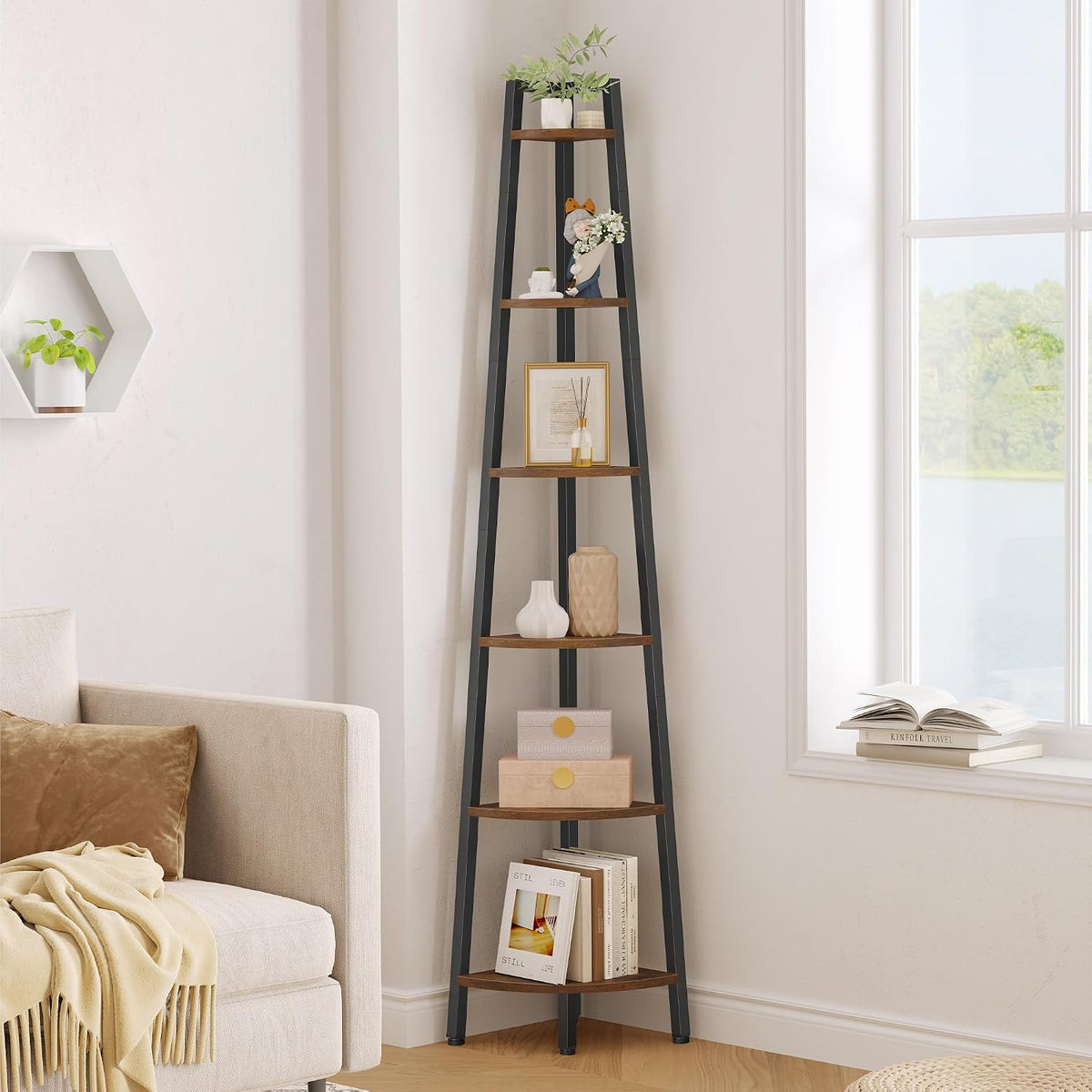Straight-on view of the tall black corner shelf with wood-toned shelves staged with vases, decorative boxes and a sofa arm