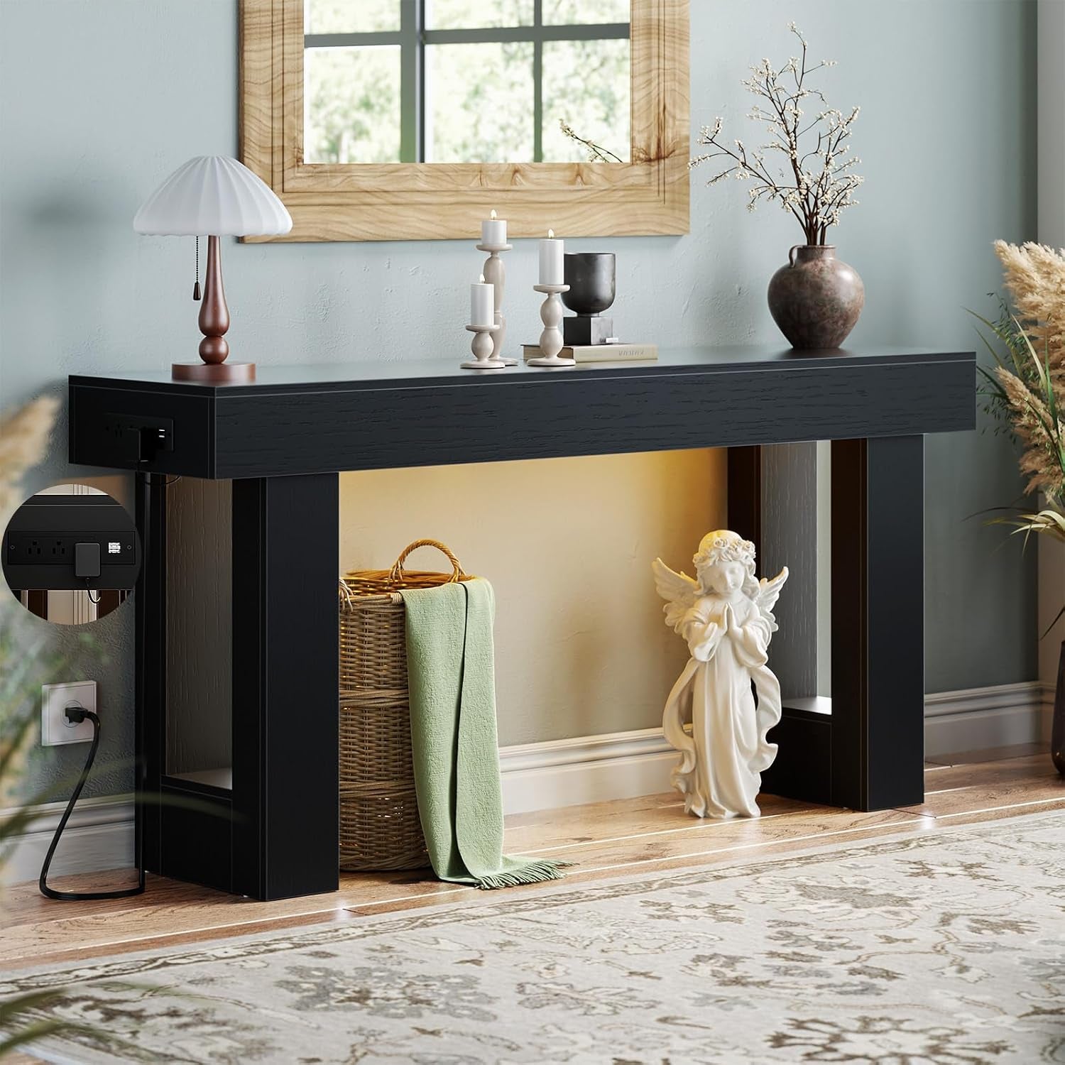 Low-angle view of a black console table showing warm underglow, plugged power cord and basket beneath