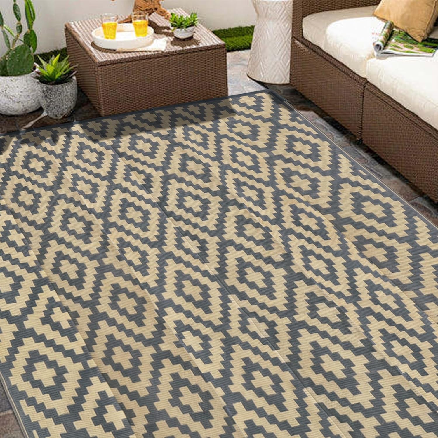 Close patio view of the reversible rug showing its repeating diamond motif near outdoor furniture.