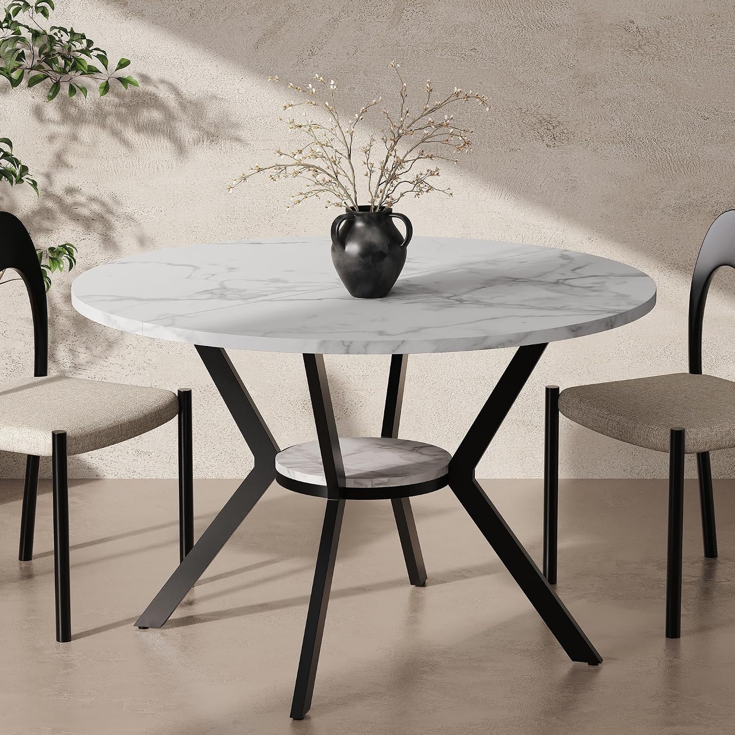 Round dining table with white marble-look top, black metal pedestal legs and lower shelf, topped with a black vase.