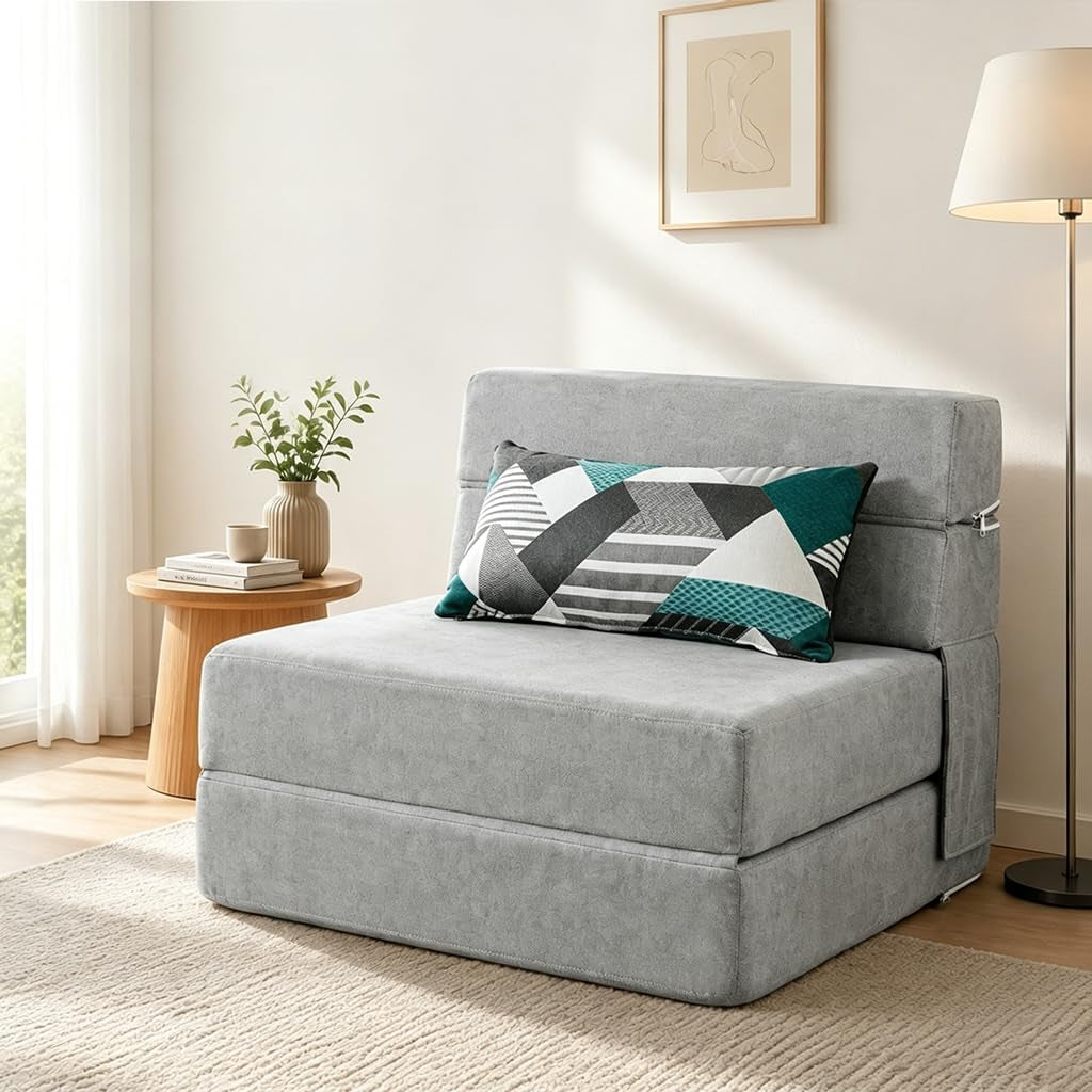 Light gray futon folded as a chair with a patterned lumbar pillow and side table