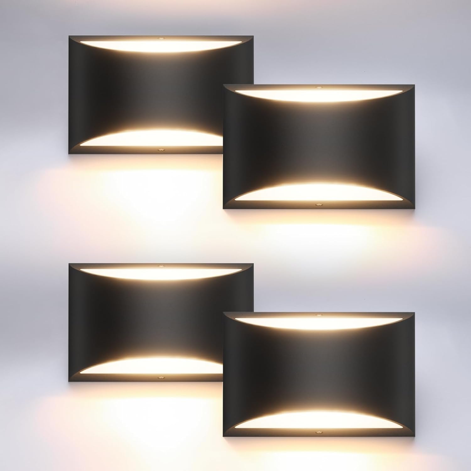 Four black rectangular wall sconces arranged in a grid, each casting warm light up and down.