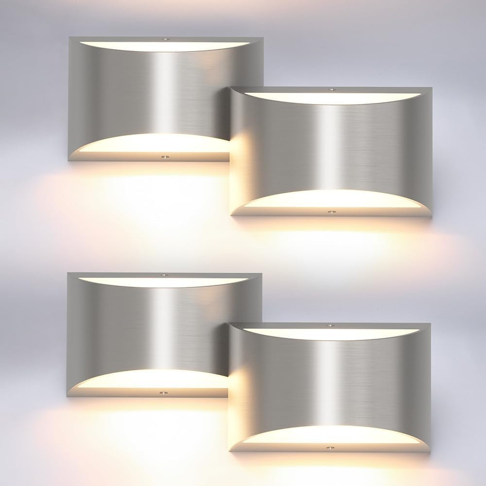 Four brushed metal wall sconces arranged in a grid, each emitting warm up-and-down light.