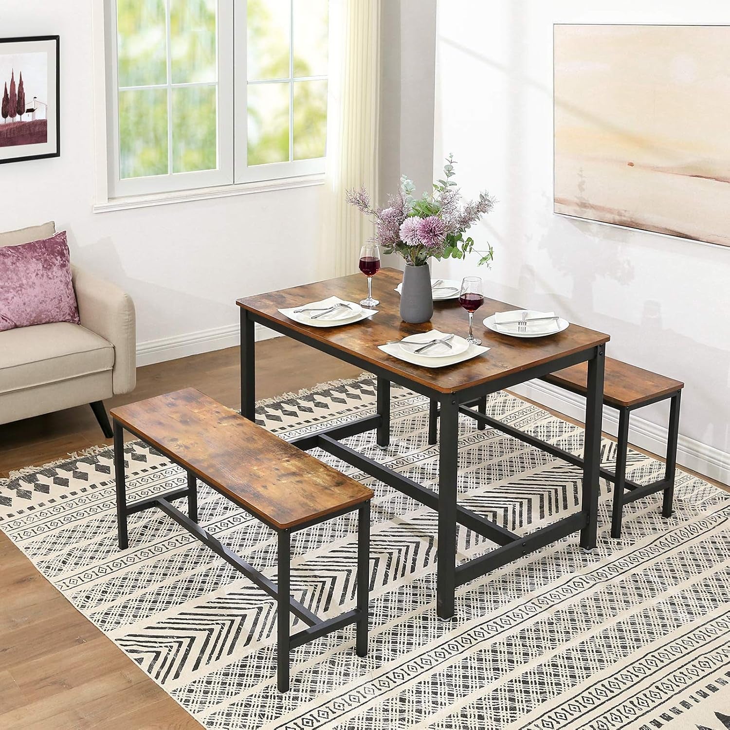 Dining table set with two benches showing a bench in front on a patterned rug in a staged room