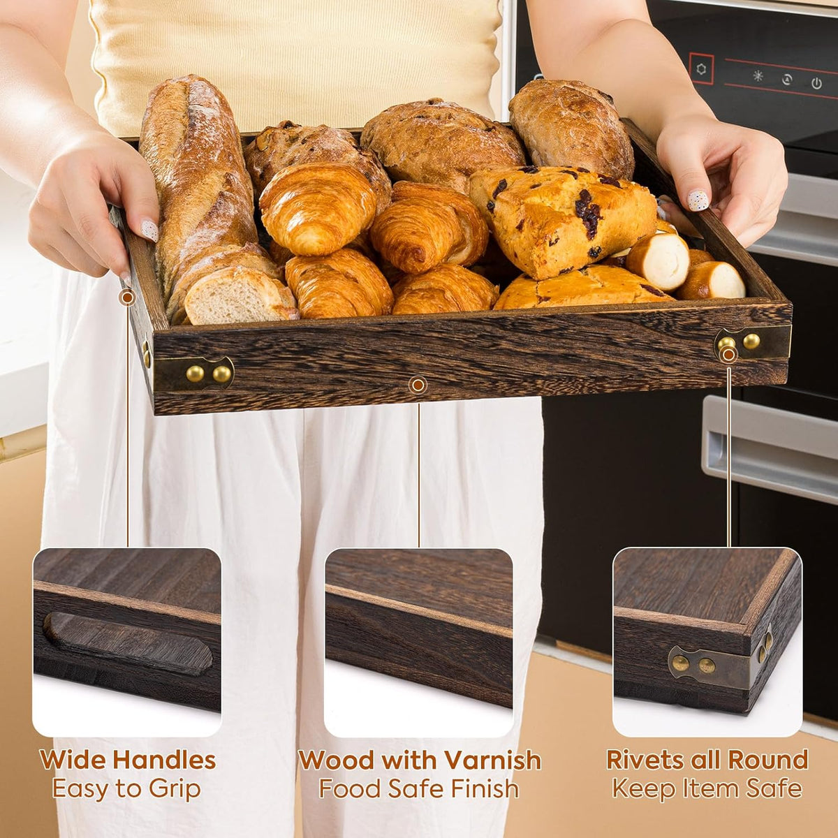 Person holding a wooden tray filled with breads and pastries, side view highlighting wide cutout handles and riveted metal-c饰