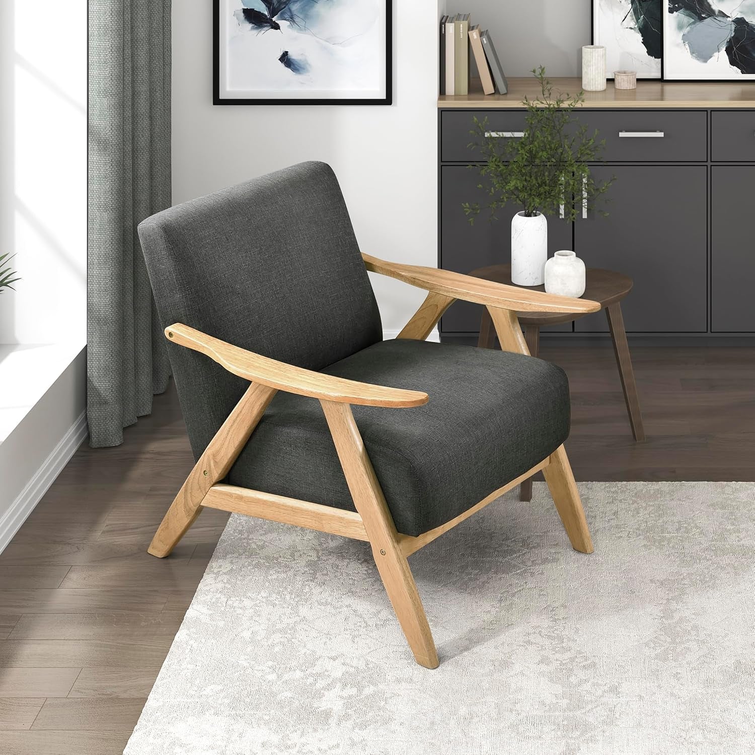 Dark gray upholstered accent chair with light wood frame in a living room corner.