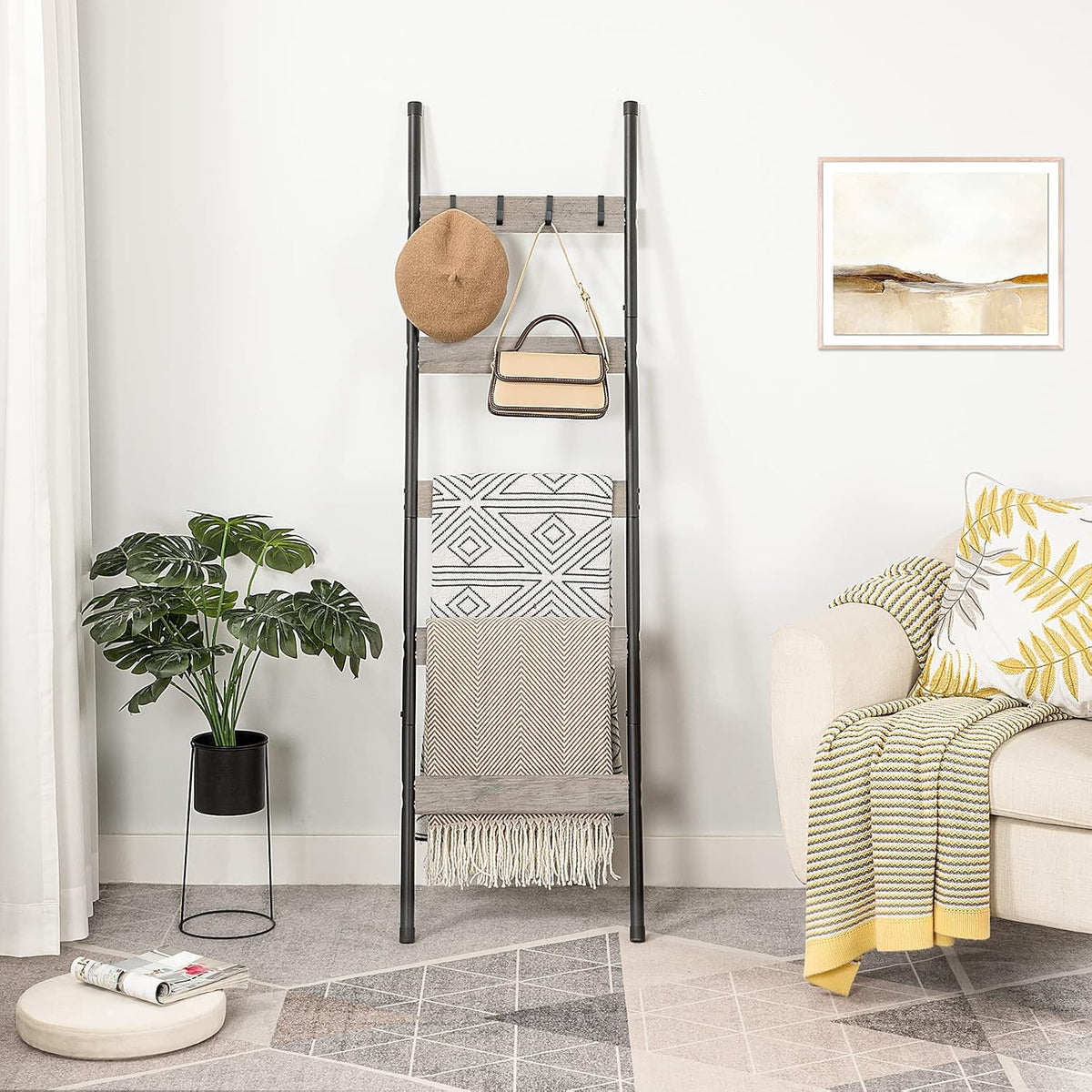 Leaning ladder styled in a living space with multiple towels draped across the shelves and a plant nearby