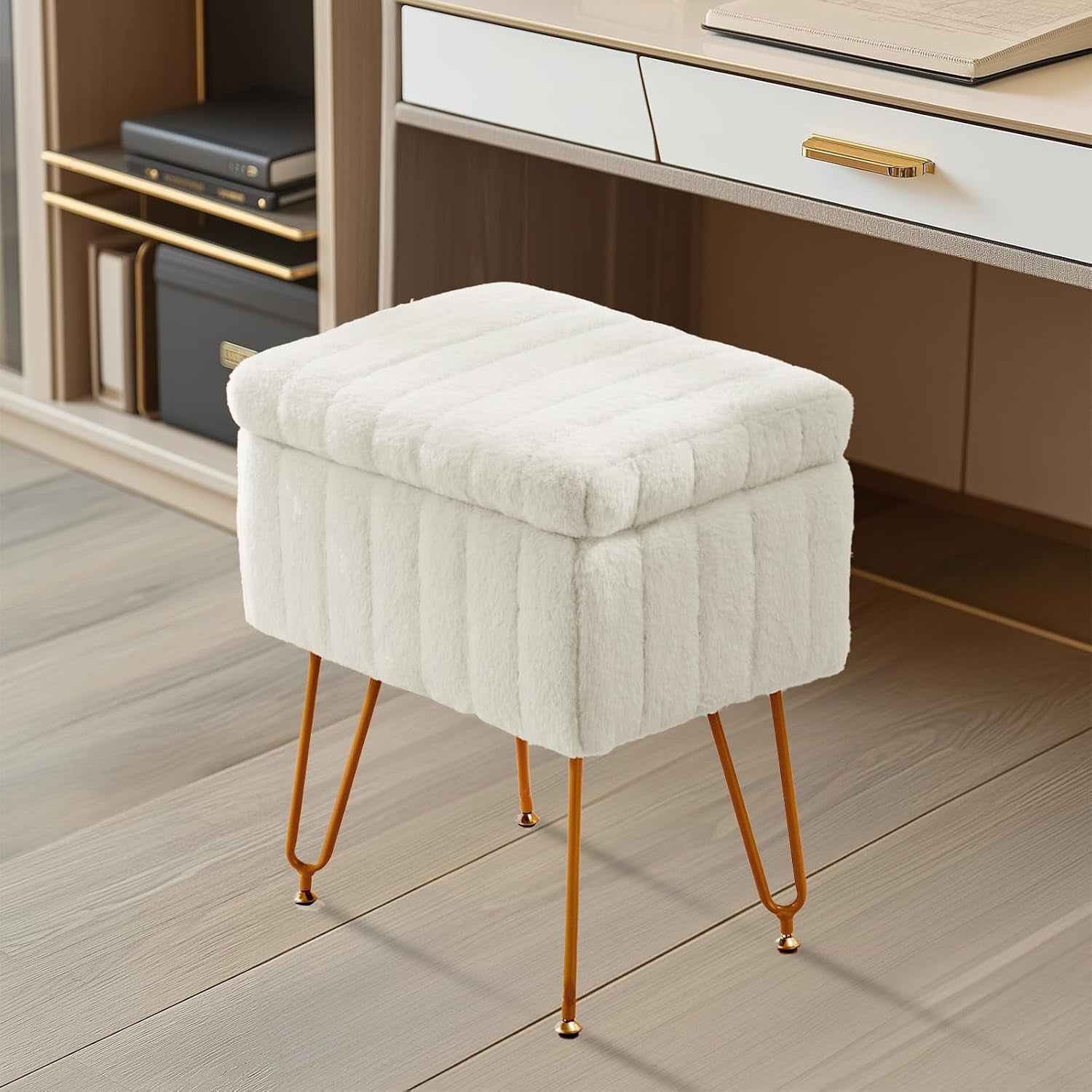 Side view of a white faux-fur storage ottoman with gold hairpin legs placed under a desk