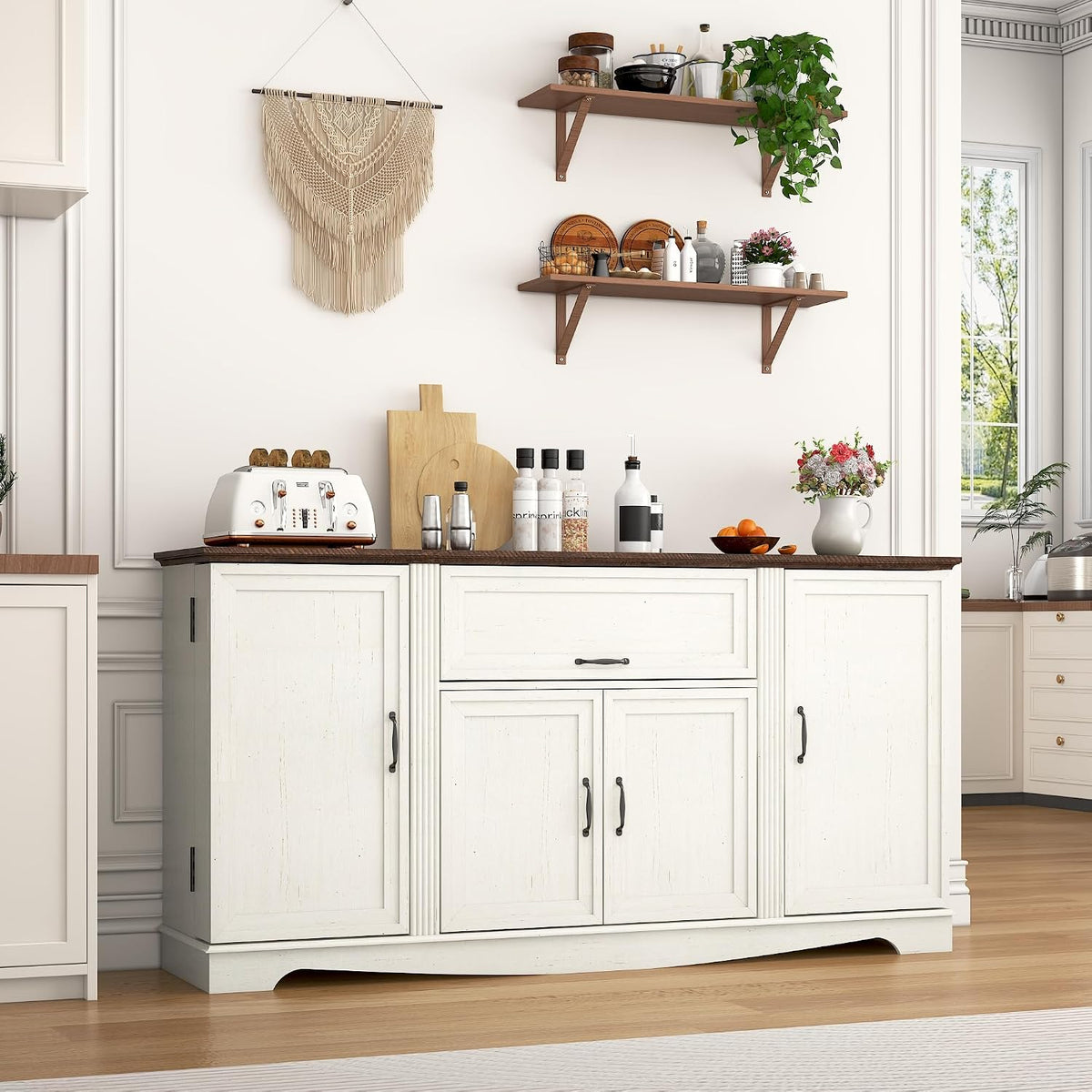 Closed antique-white sideboard with dark wood tabletop styled with kitchen decor on top