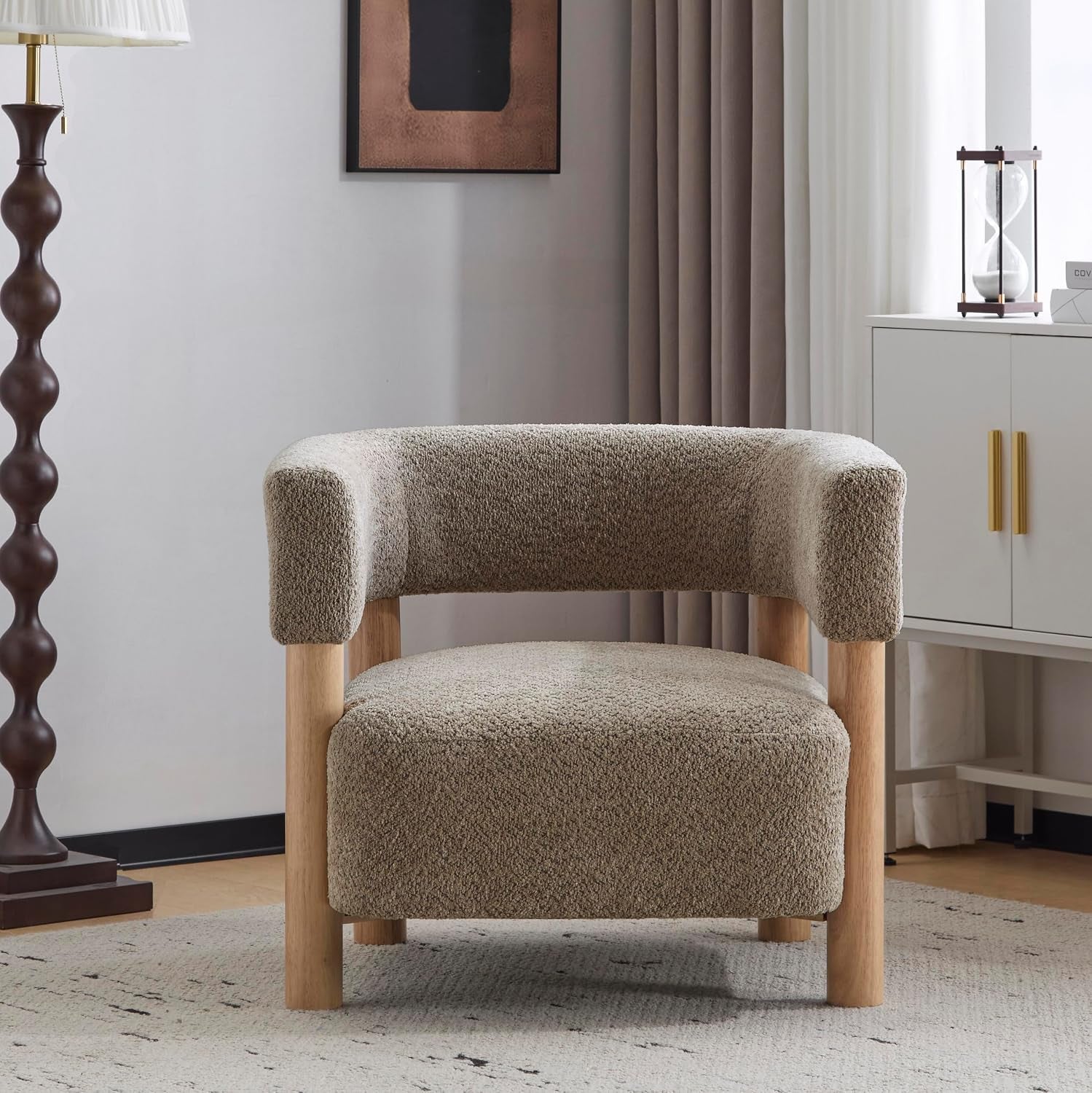 Light camel boucle accent chair staged in a room with lamp and sideboard, front-facing view