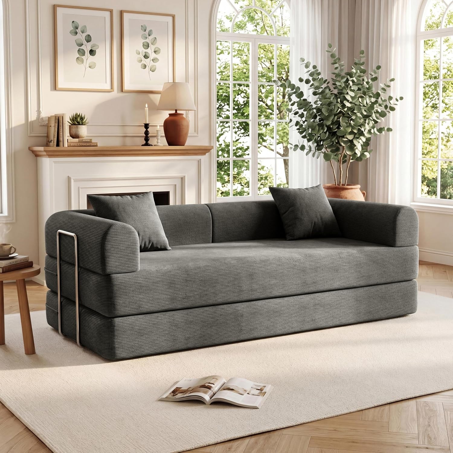 Charcoal gray corduroy sofa in upright sofa configuration with two throw pillows in a bright living room.