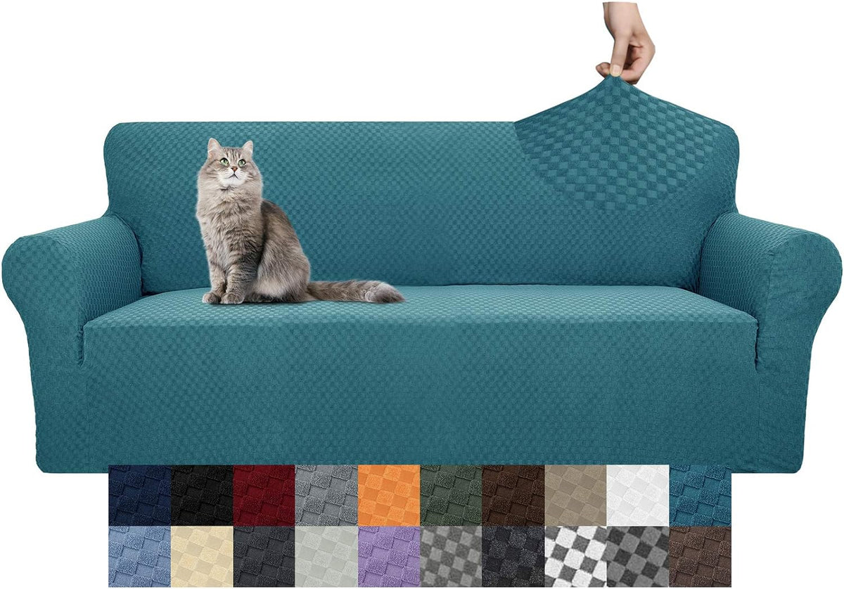 Three-seat teal stretch slipcover on a sofa with a gray long-haired cat seated and a corner of fabric lifted to show texture
