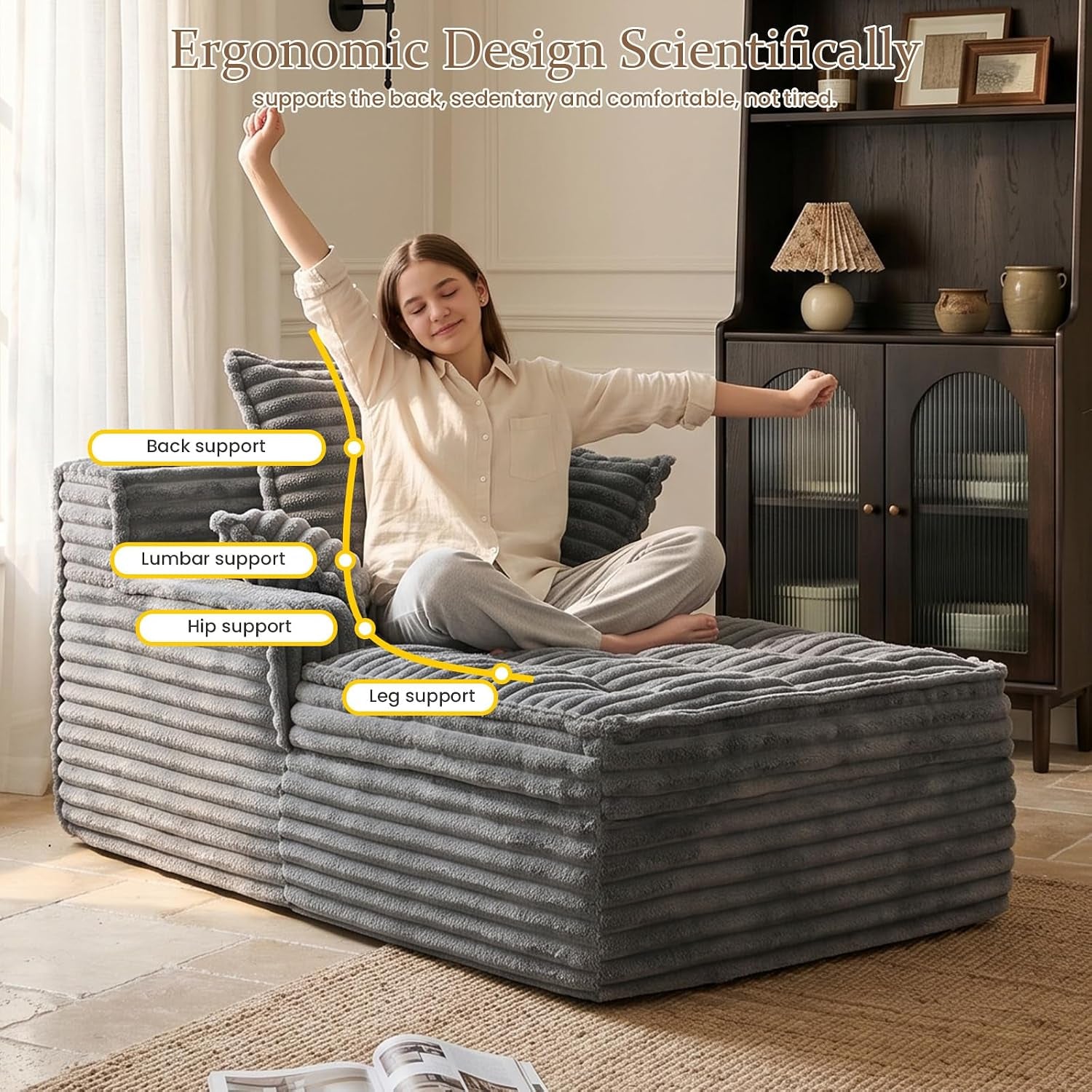 Woman sitting cross-legged on a gray corduroy chaise with labeled ergonomic support points.
