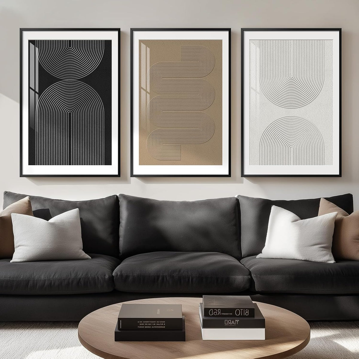 Three framed geometric line-art posters in black, bronze and white above a black sofa and round coffee table.