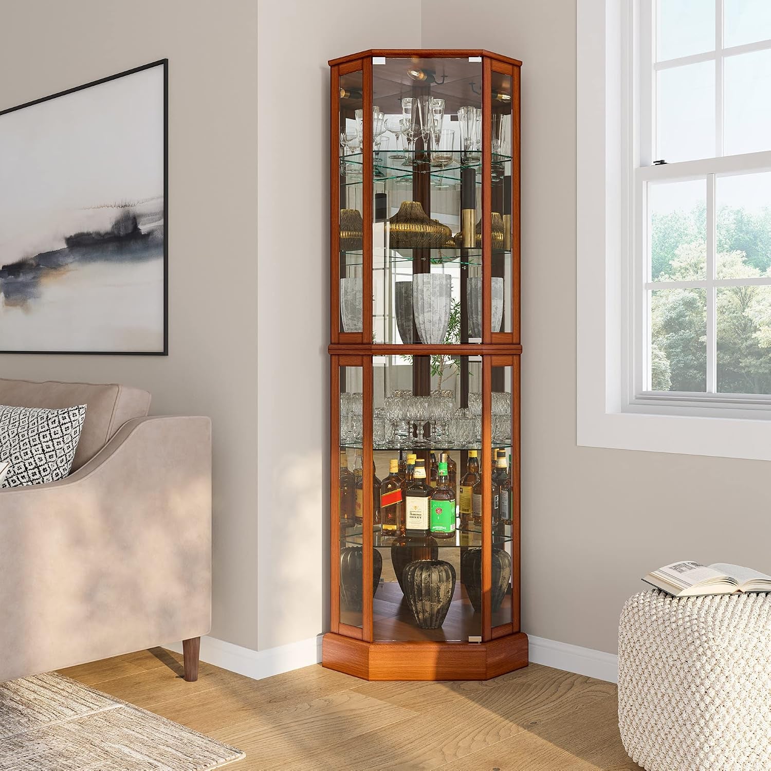 Oak finish corner display cabinet placed in a living room corner with decorative objects on glass shelves