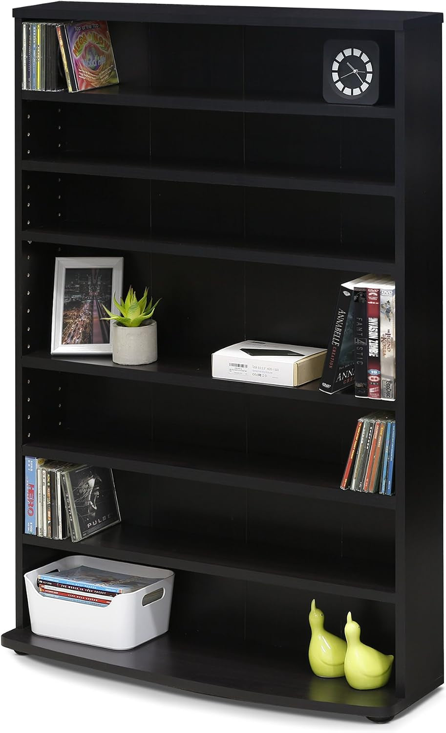 Front view of a black 8-shelf tower staged with books, a clock and decorative items on a curved base