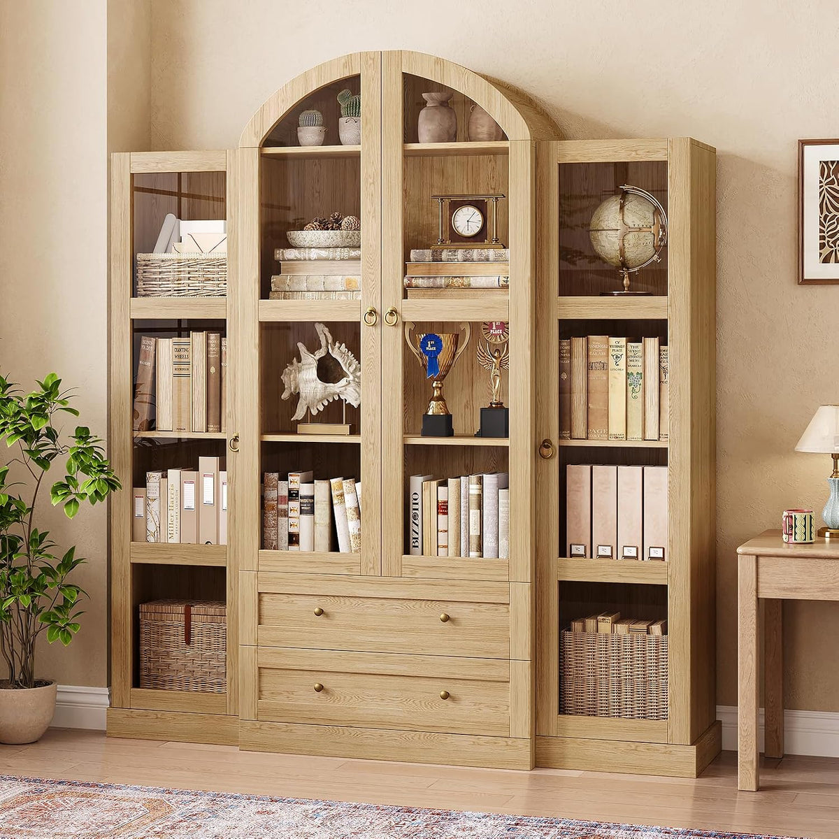 Full front view of a tall light-wood cabinet with framed glass doors, drawers and displayed decor.