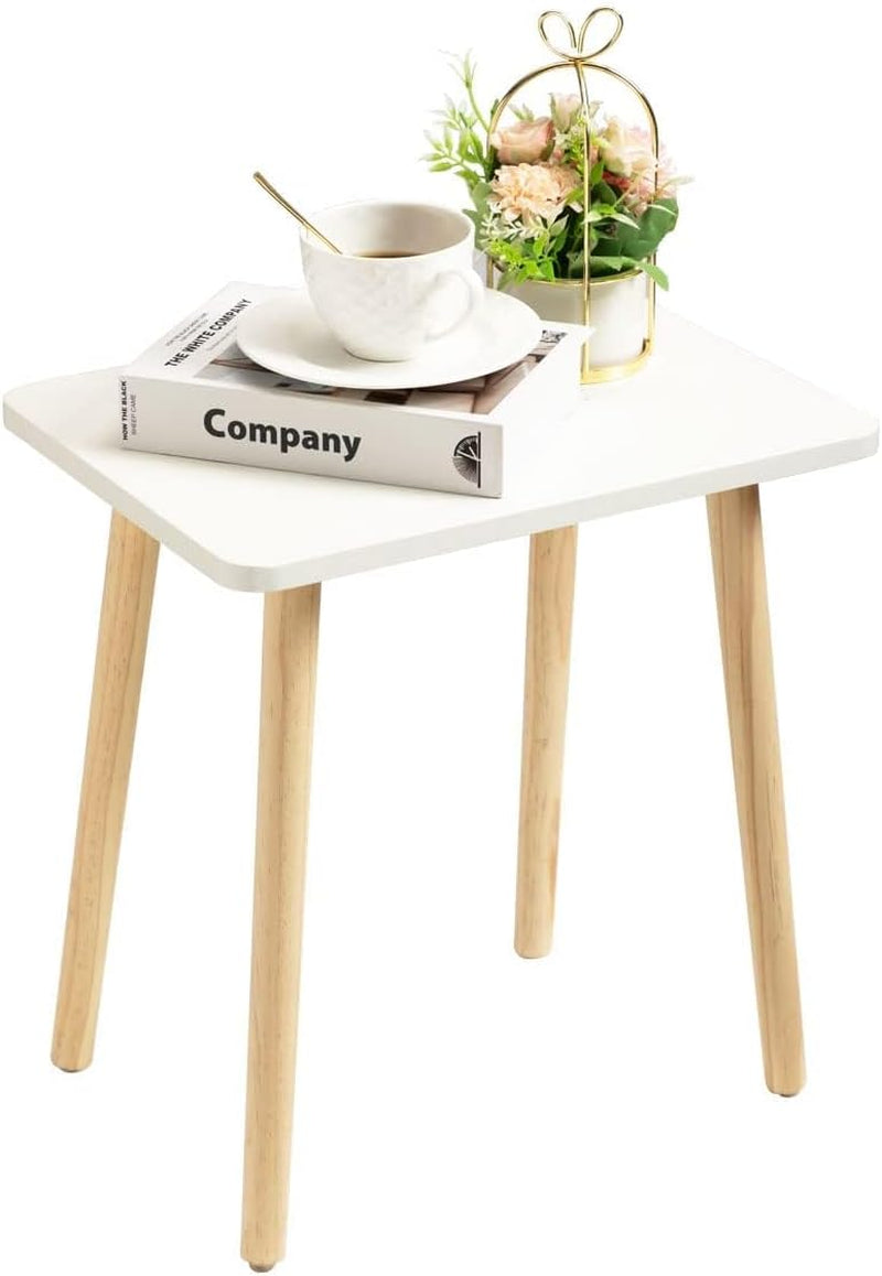 White square side table with natural wood tapered legs angled front view with cup and book on top