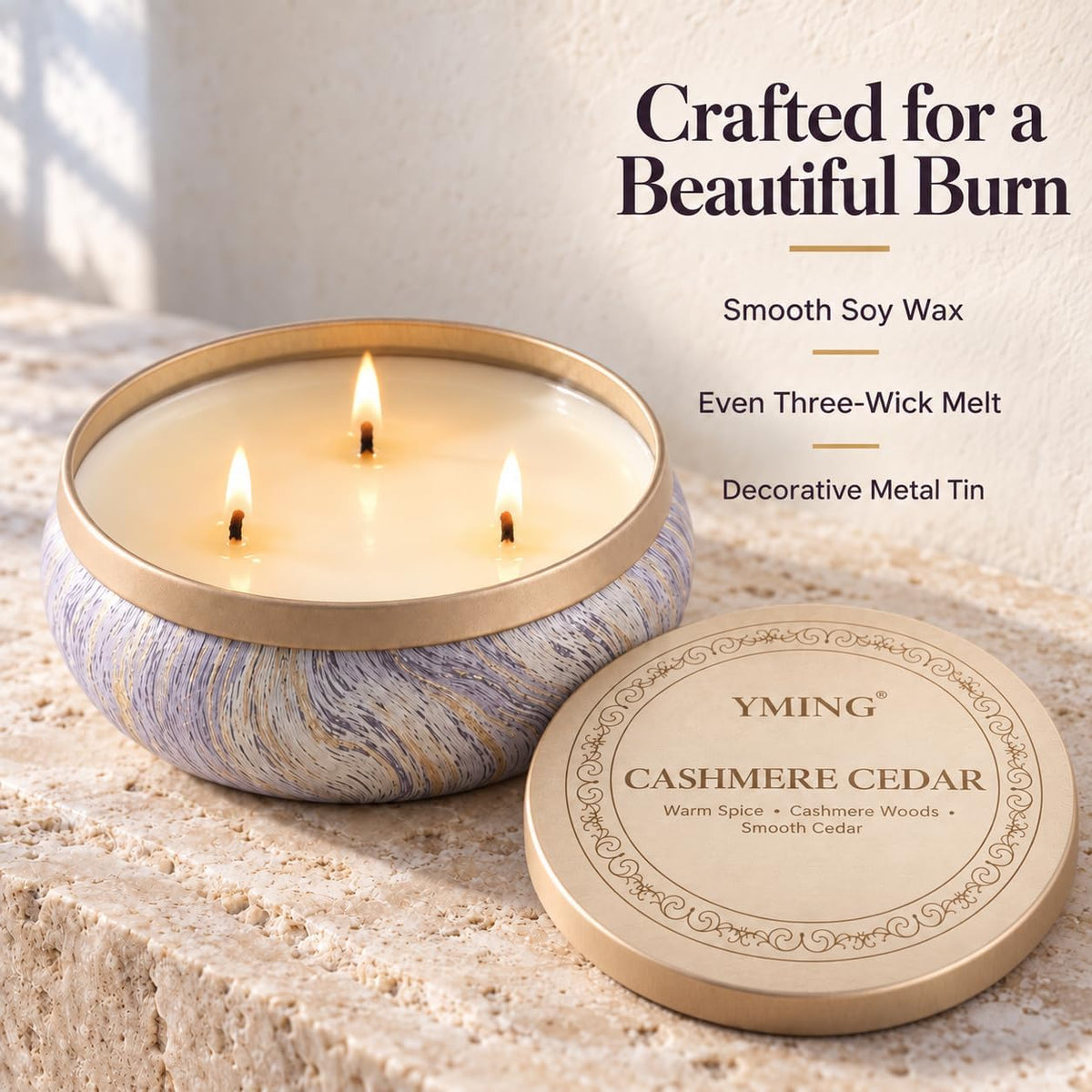 Gift box with bow held by hands in a holiday living-room setting next to stacked candle tins
