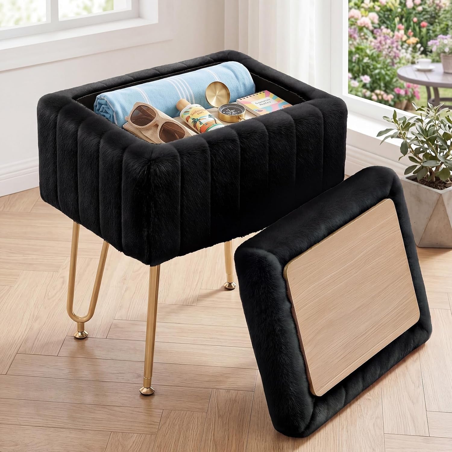 Black faux-fur storage ottoman with open top revealing folded towel and accessories, detached lid showing wood underside and