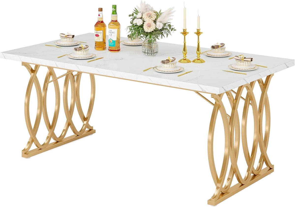 Studio shot of a rectangular white faux-marble table with gold interlocking oval metal legs, set with dishes, candles and a