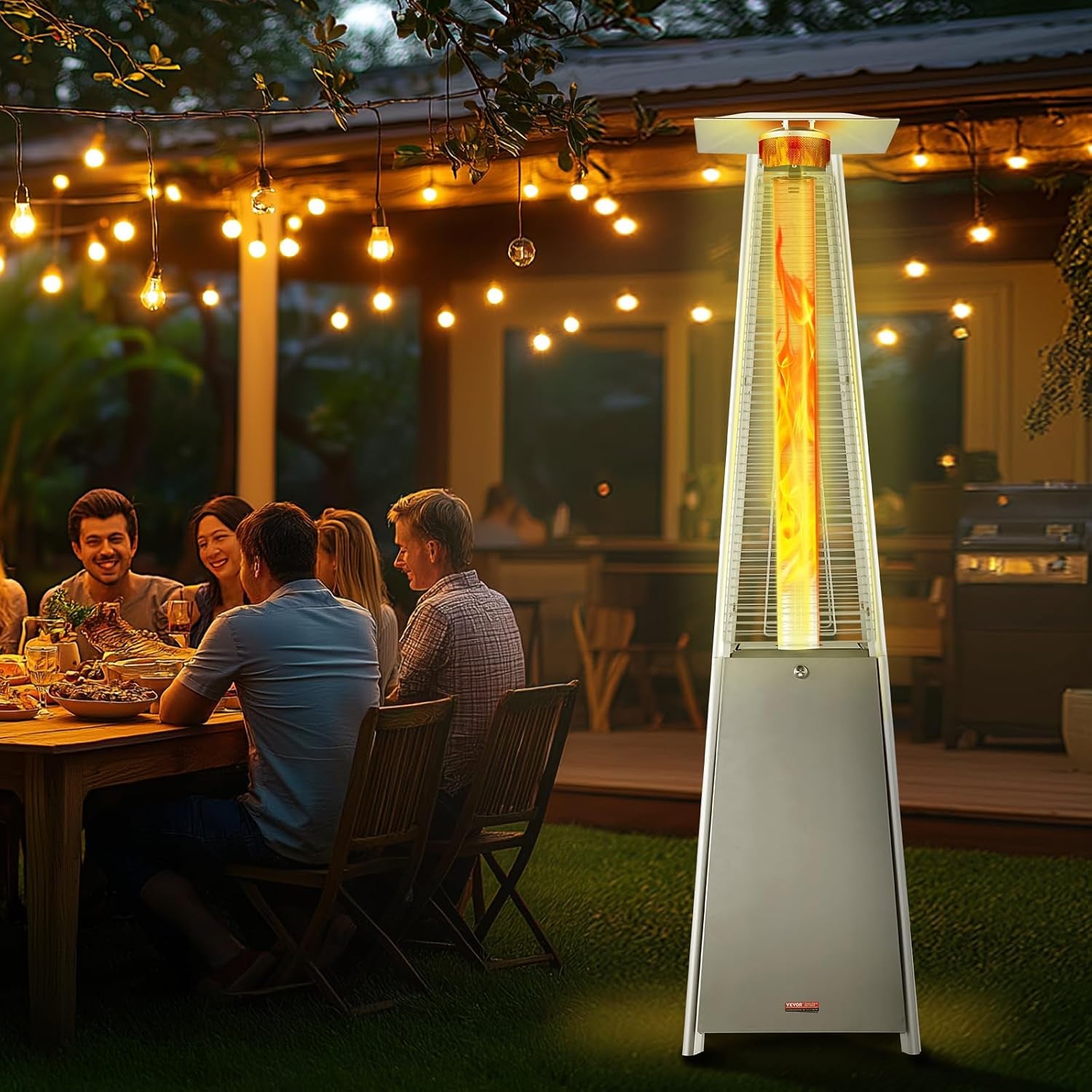 Outdoor evening scene with a glowing patio heater next to a group dining at a table under string lights.