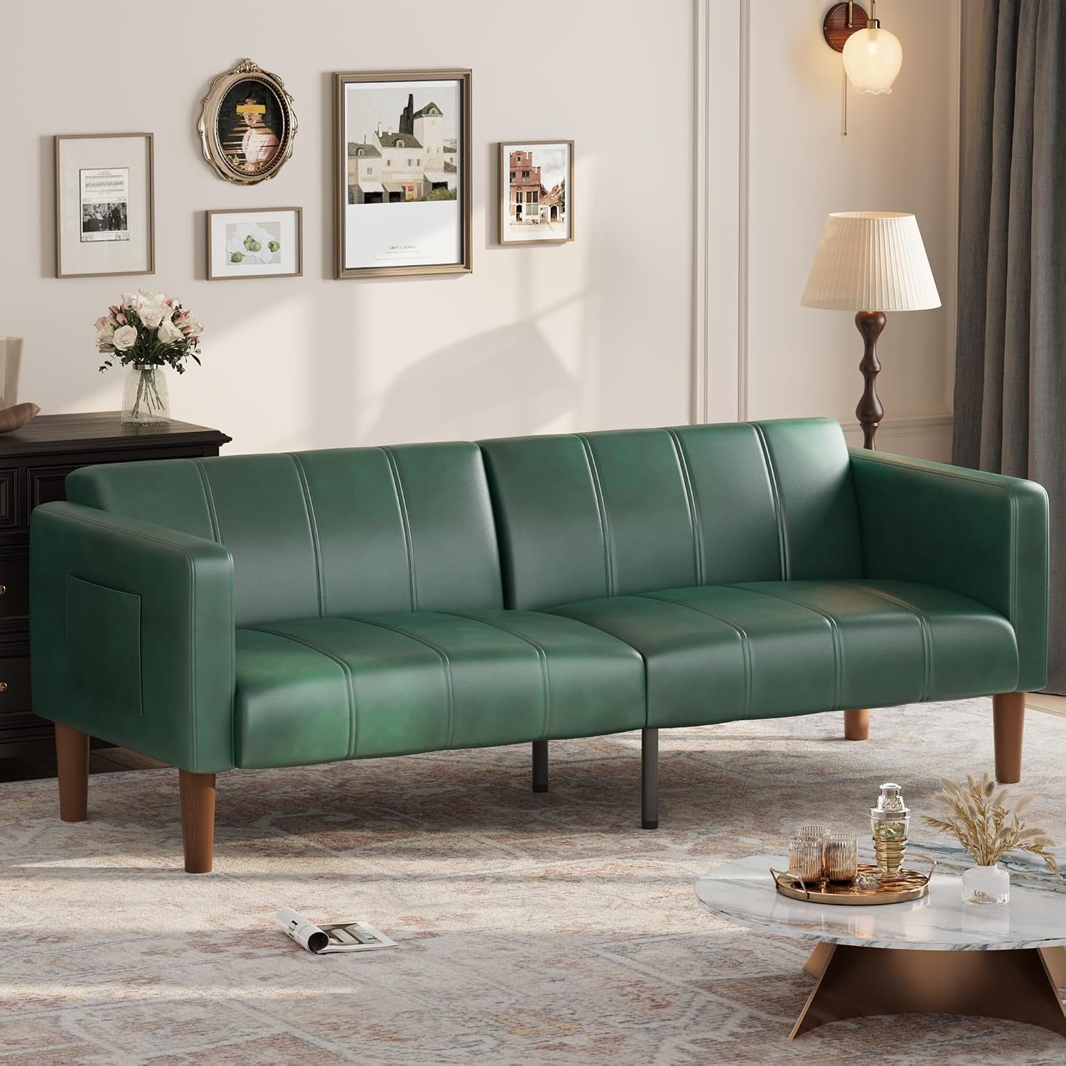 Three‑seat green faux‑leather futon sofa shown in a decorated living room