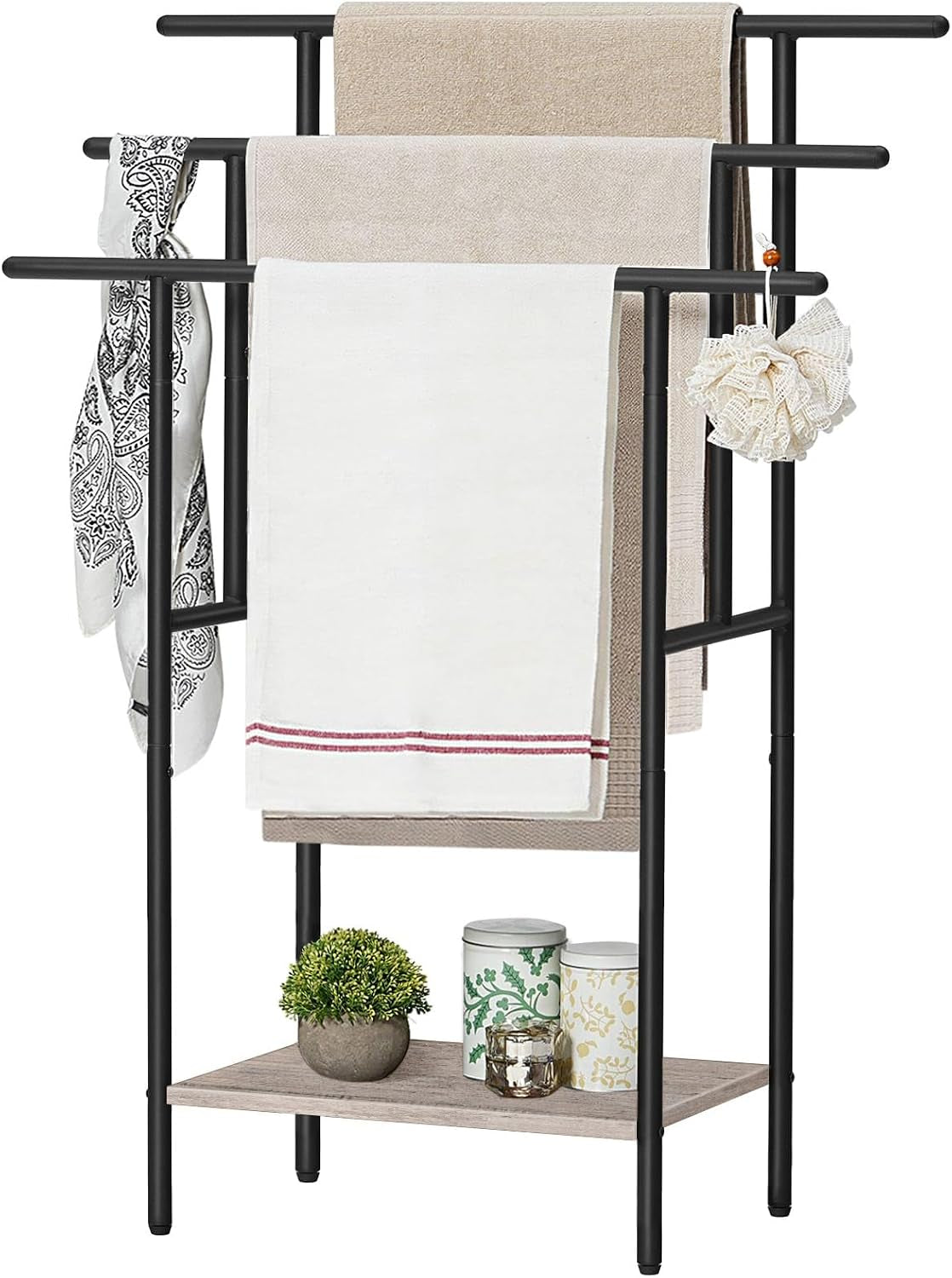Straight front view of the black-framed towel rack with a light greige wood-look shelf, towels and small decorative cans on